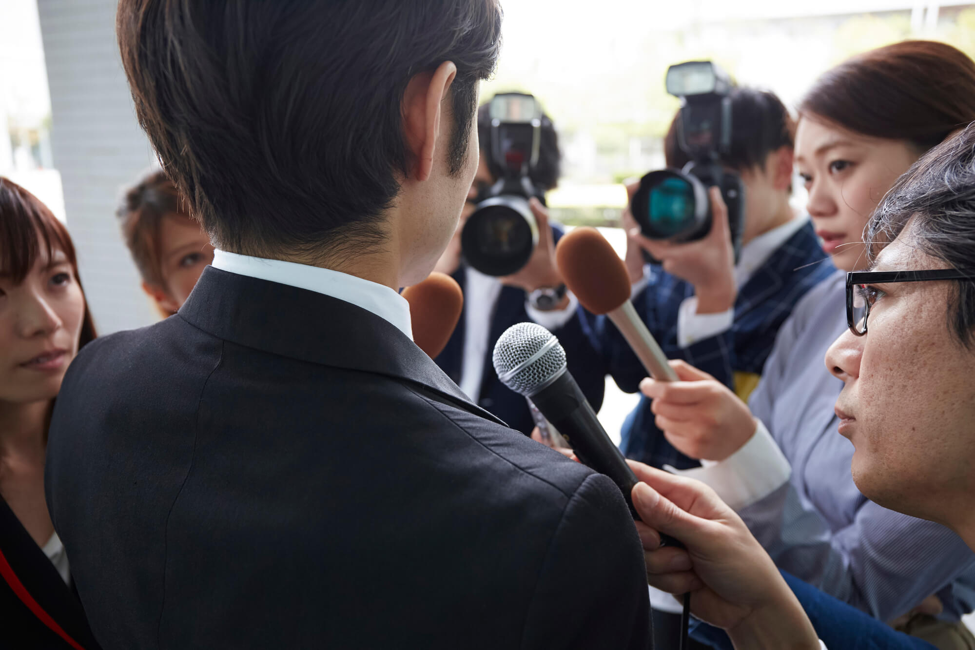マスコミに囲まれる企業の代表