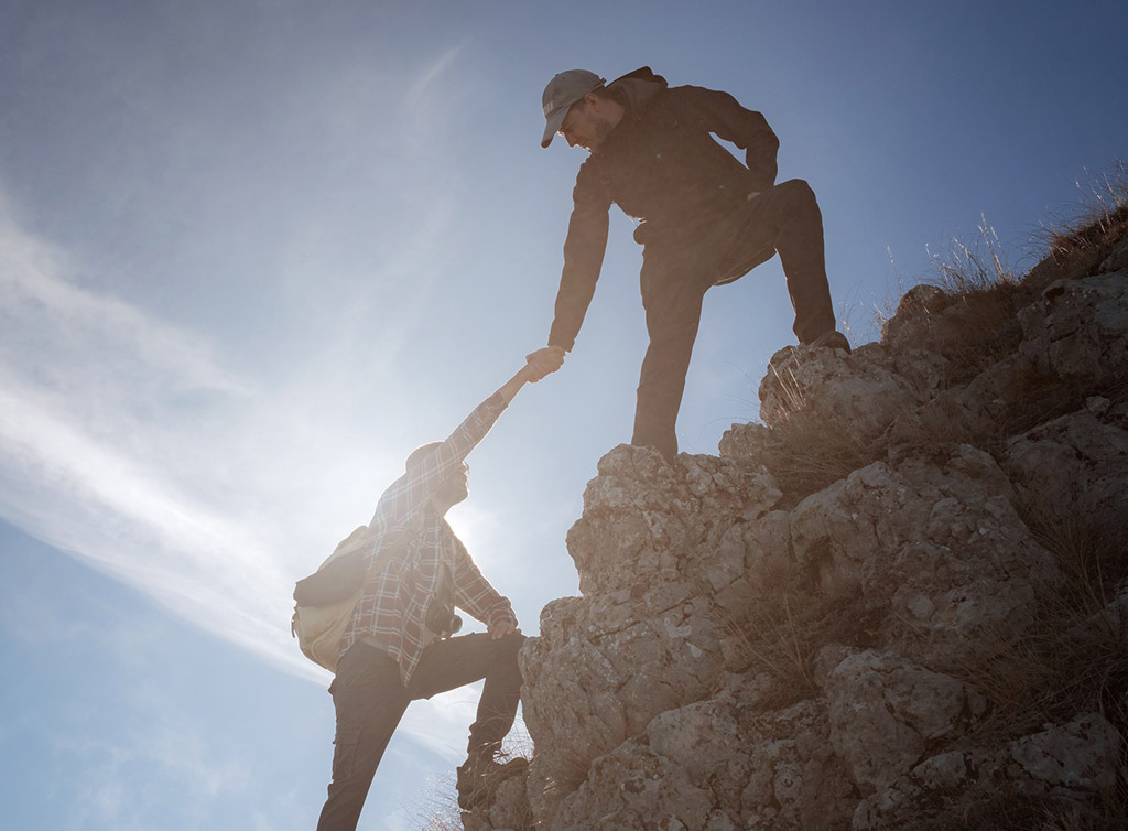 山頂で助け合う参加者の様子